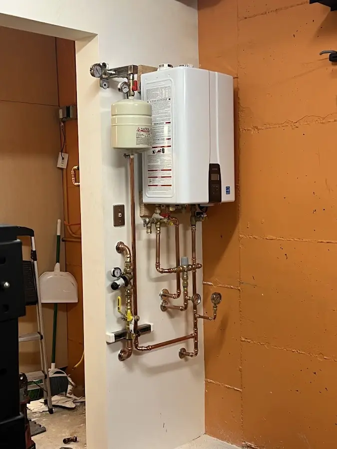 Plumbing technician inspecting water heater connections in Richfield